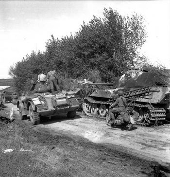 Manitoba Dragoons Staghound passes an abandoned Tiger II